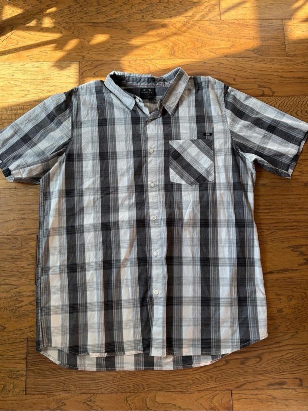 Oakley men’s short-sleeve button-up in a gray/black/white plaid pattern. Size L.